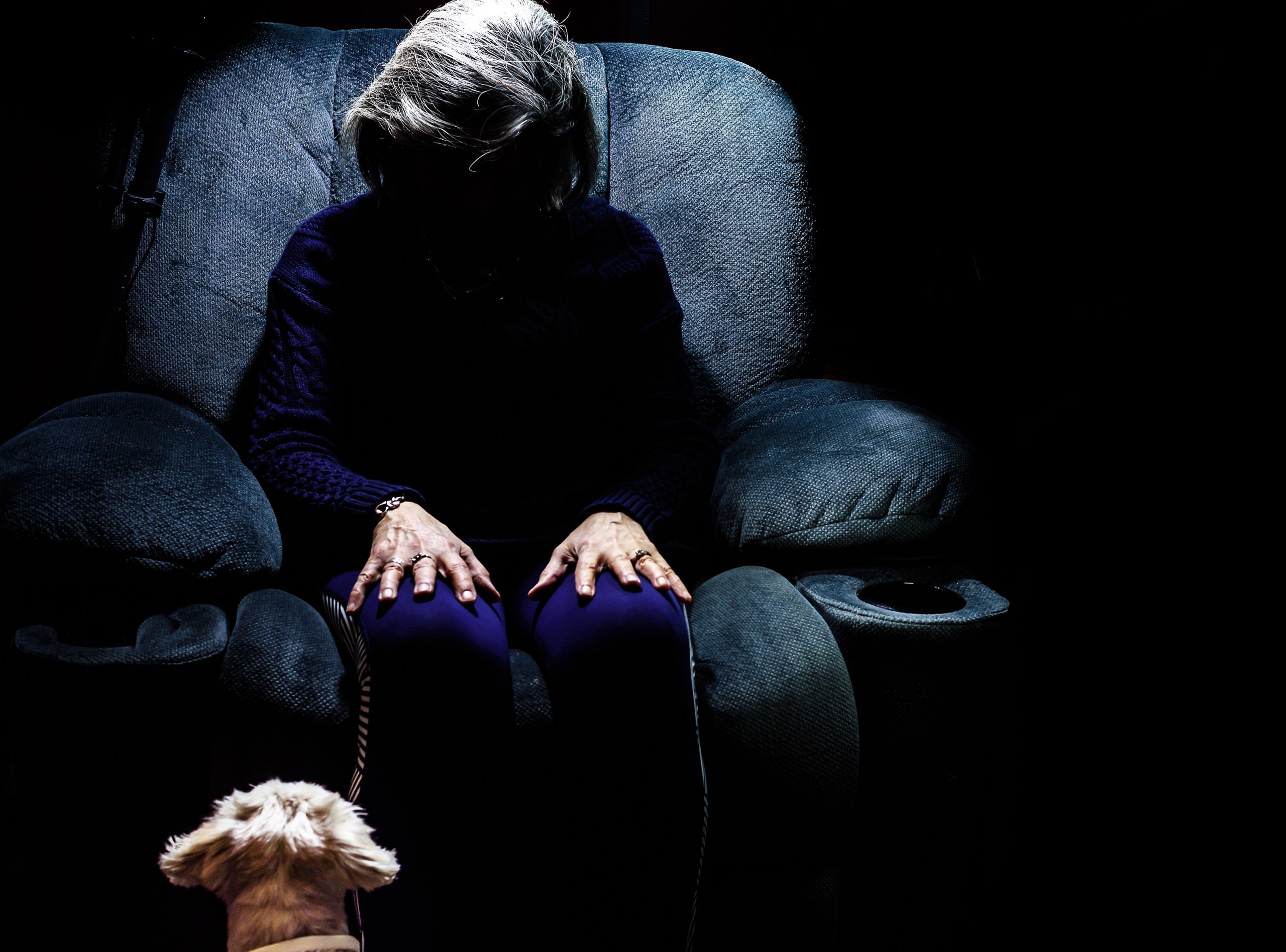 elderly woman sitting alone in the dark