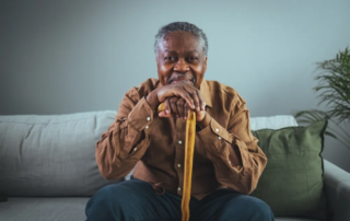 Portrait of a happy senior man smiling while holding his cane.